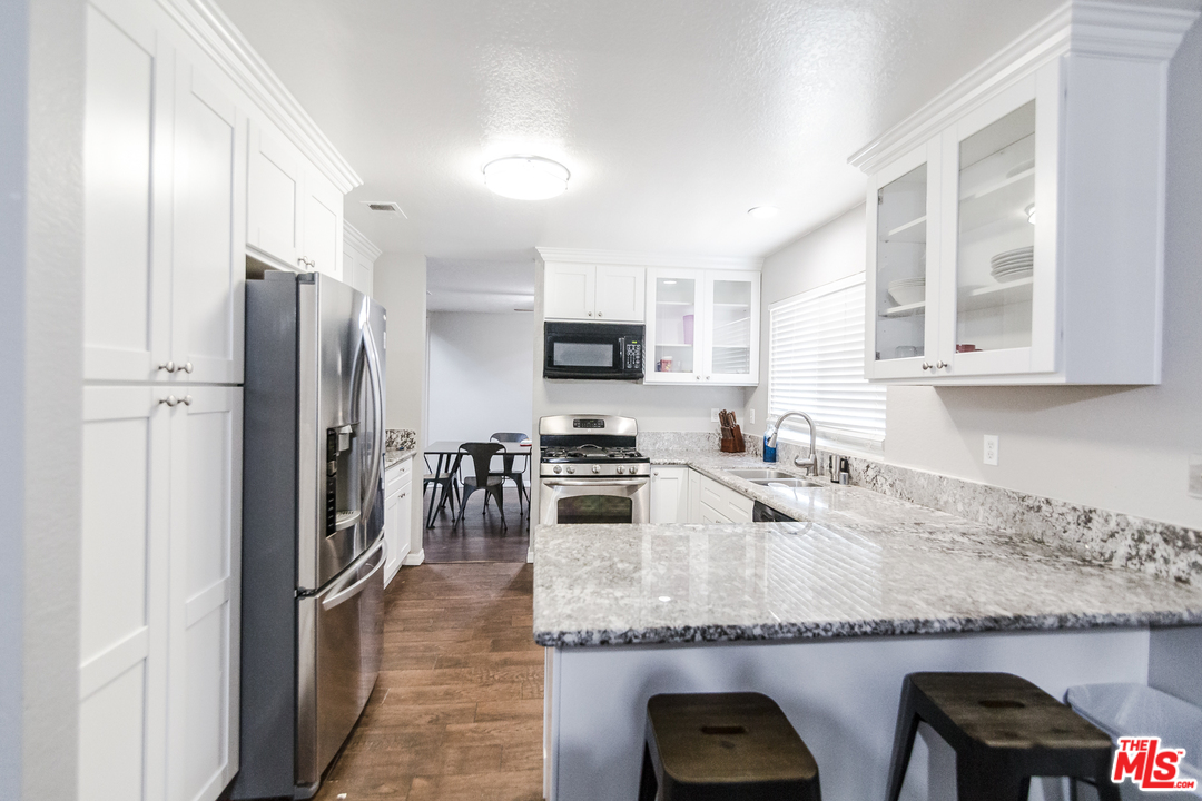 2985 North Chestnut Street Rialto, CA 92376 - Photo 13 of 30 a kitchen with granite countertop a refrigerator stove and sink