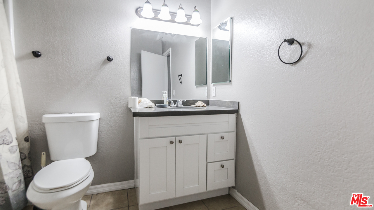 2985 North Chestnut Street Rialto, CA 92376 - Photo 17 of 30 a bathroom with a toilet sink vanity and mirror