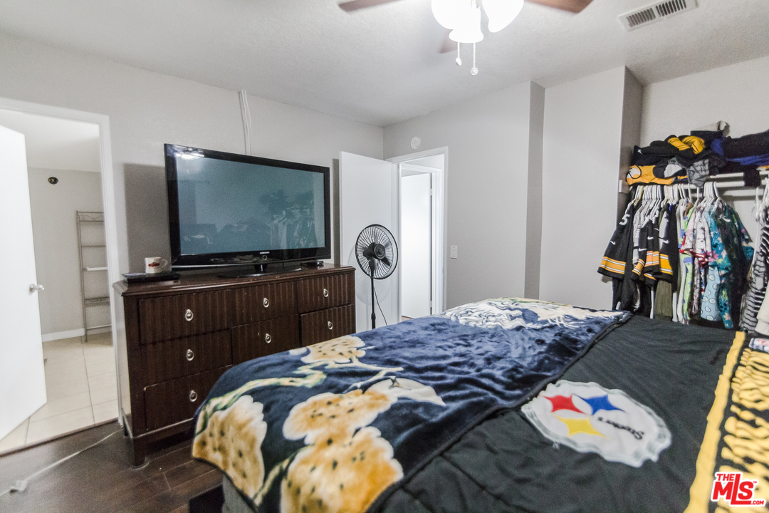 2985 North Chestnut Street Rialto, CA 92376 - Photo 20 of 30 a bedroom with a bed and a flat tv screen on dresser