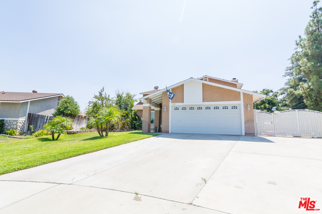 2985 North Chestnut Street Rialto, CA 92376 - Photo 3 of 30 a front view of a house with a yard and garage