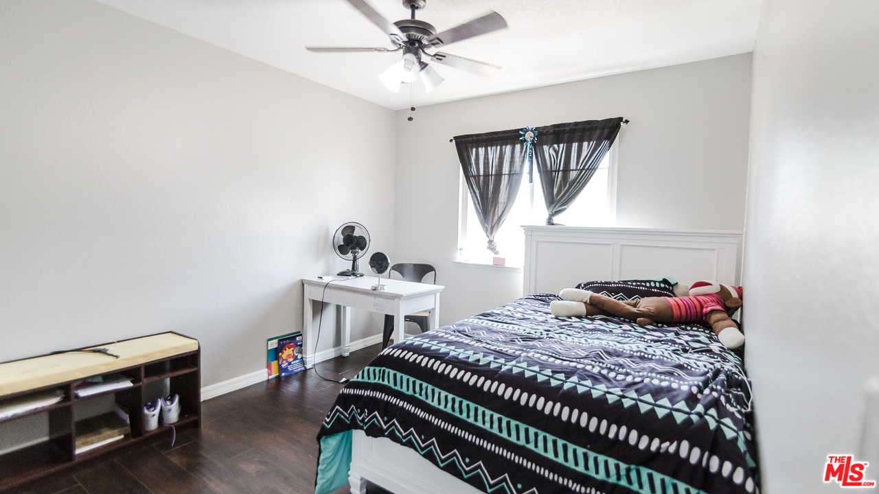 2985 North Chestnut Street Rialto, CA 92376 - Photo 24 of 30 a bedroom with a bed and a chandelier