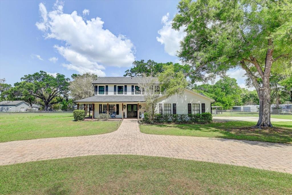 4710 Stearns Road Valrico, FL 33596 - Photo 2 of 63 a front view of a house with a yard and trees