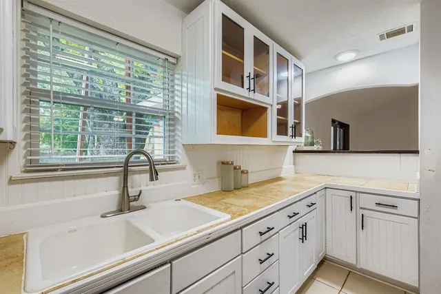 a kitchen with cabinets stainless steel appliances a sink and a large window