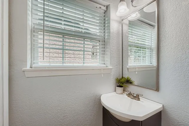 a bathroom with a sink a mirror and a window