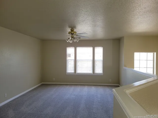 an empty room with a windows and chandelier