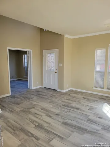 a view of an empty room and window and wooden floor