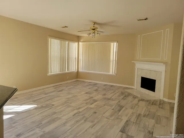 a view of empty room with wooden floor and fireplace