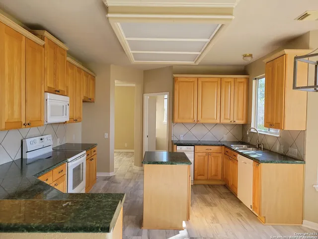 a large kitchen with stainless steel appliances granite countertop a sink and a stove