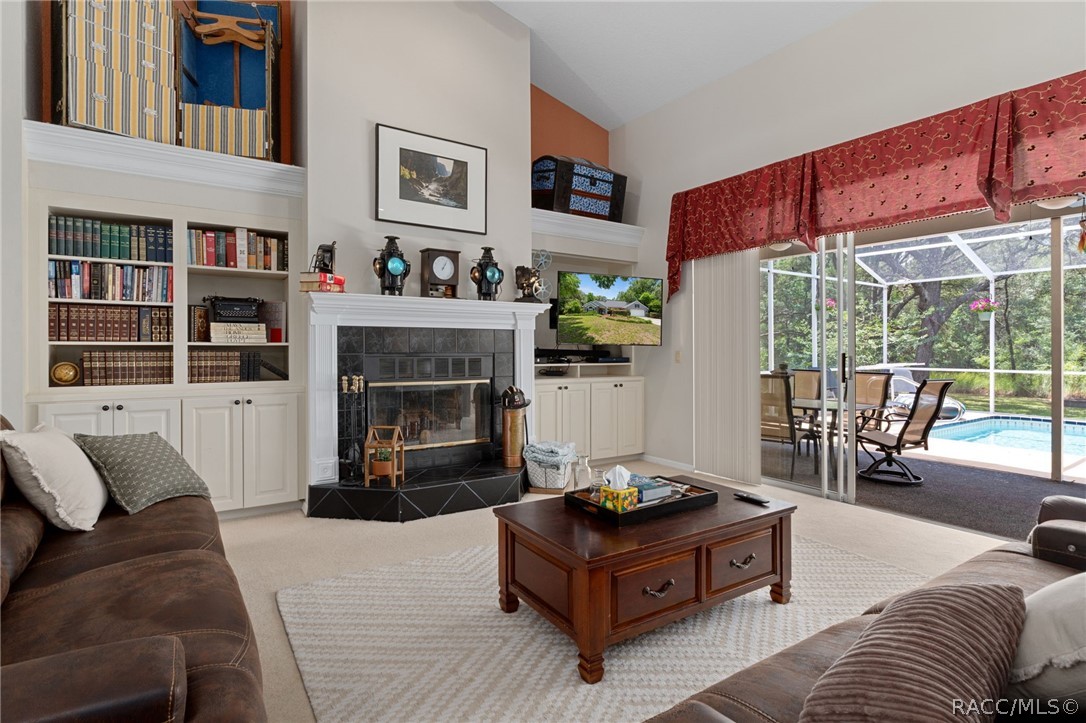 2460 West Pine Ridge Boulevard Beverly Hills, FL 34465 - Photo 6 of 47 a living room with furniture a flat screen tv and a fireplace