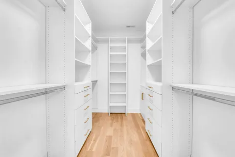 a view of walk in closet with empty racks