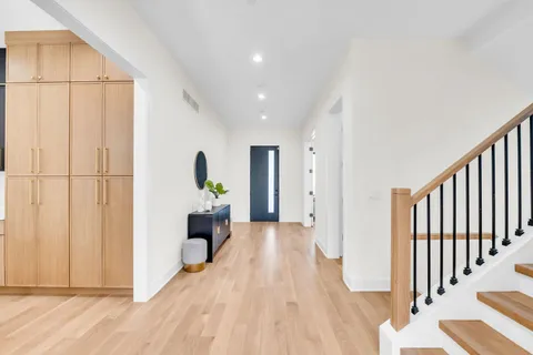 a view of a hallway view with wooden floor and staircase