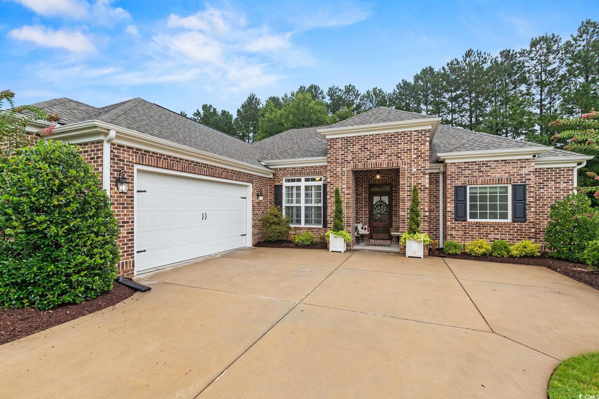 236 Chamberlin Road Myrtle Beach, SC 29588 - Photo 1 of 35 View of front of property featuring roof with shingles, brick siding, concrete driveway, and an attached garage
