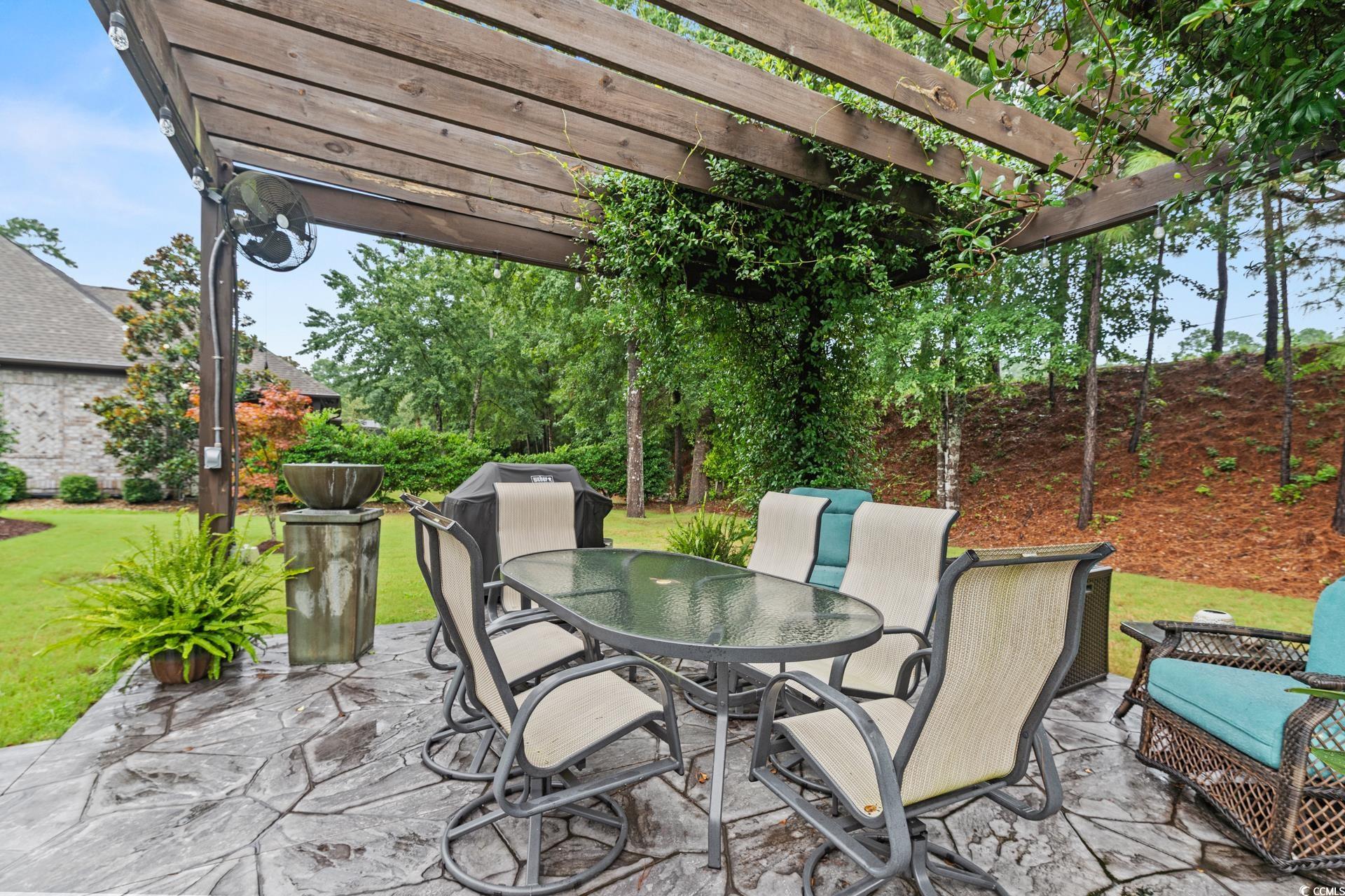 236 Chamberlin Road Myrtle Beach, SC 29588 - Photo 32 of 35 Wooden deck with outdoor dining space, a pergola, a lawn, and a patio