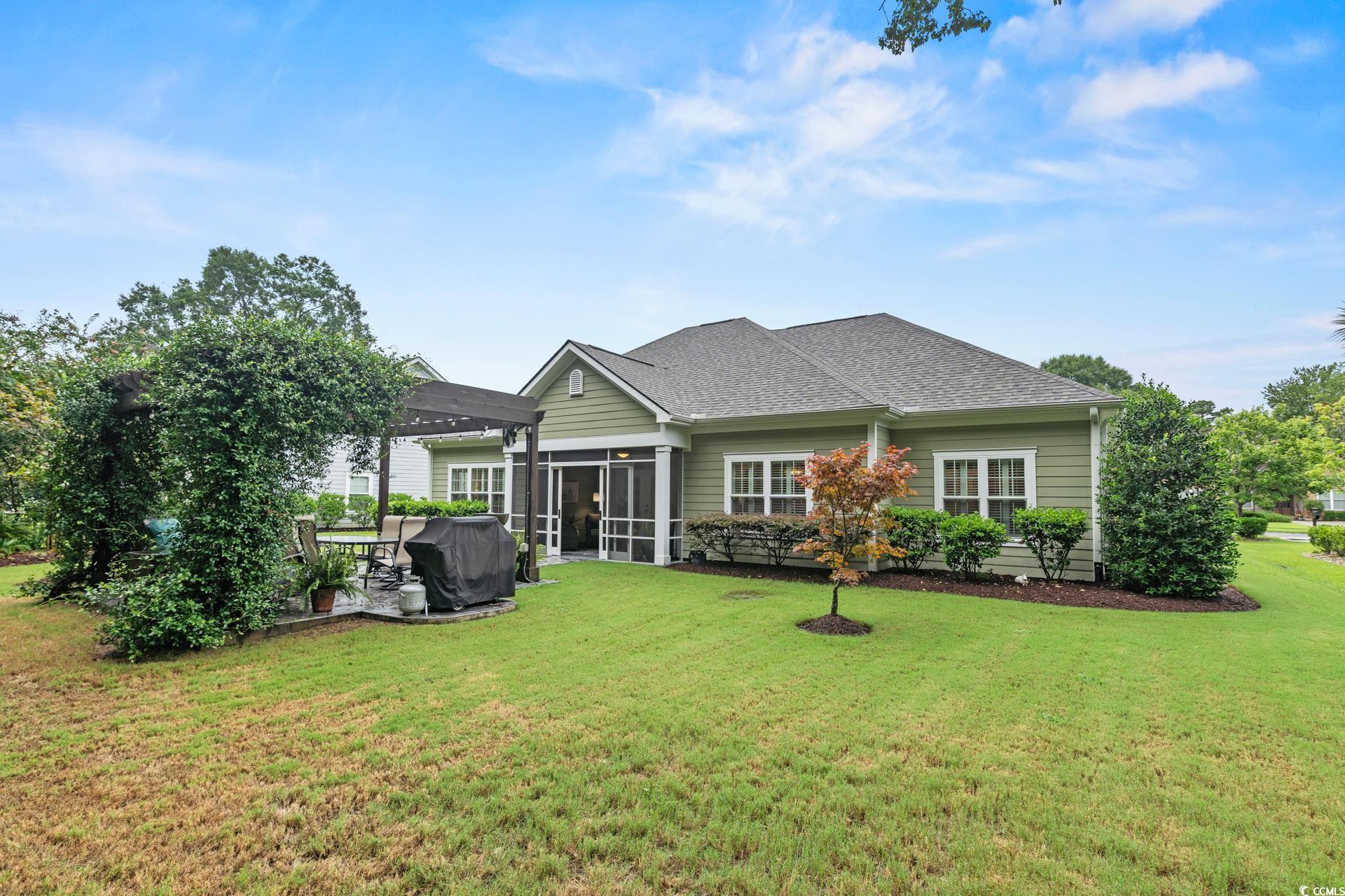 236 Chamberlin Road Myrtle Beach, SC 29588 - Photo 35 of 35 Rear view of property with a sunroom, a shingled roof, a yard, and a pergola