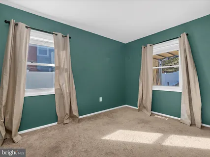 a view of an empty room with window and stairs