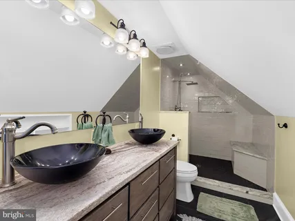 a bathroom with a granite countertop sink a toilet and a mirror