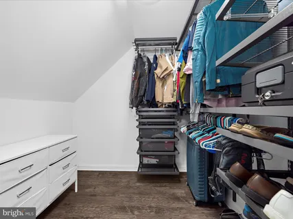 a view of walk in closet with clothes and shoes