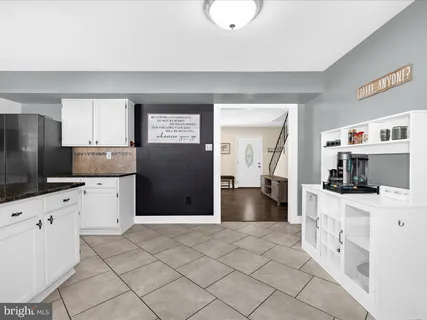 a kitchen with granite countertop a refrigerator and a stove top oven