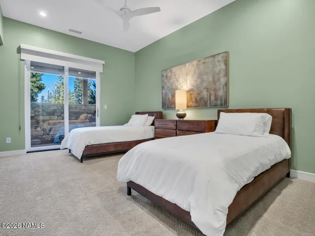 a bedroom with two beds and large window