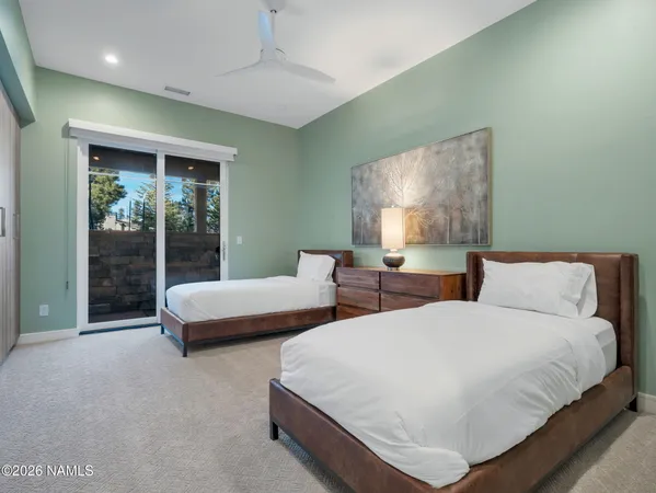 a spacious bedroom with two bed and a large window