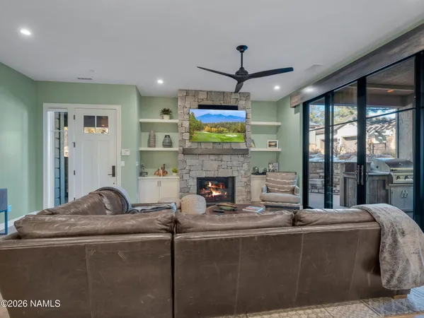 a living room with fireplace furniture and a large window