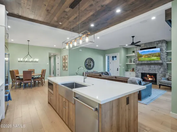a kitchen with stainless steel appliances granite countertop a sink a stove and a wooden floors