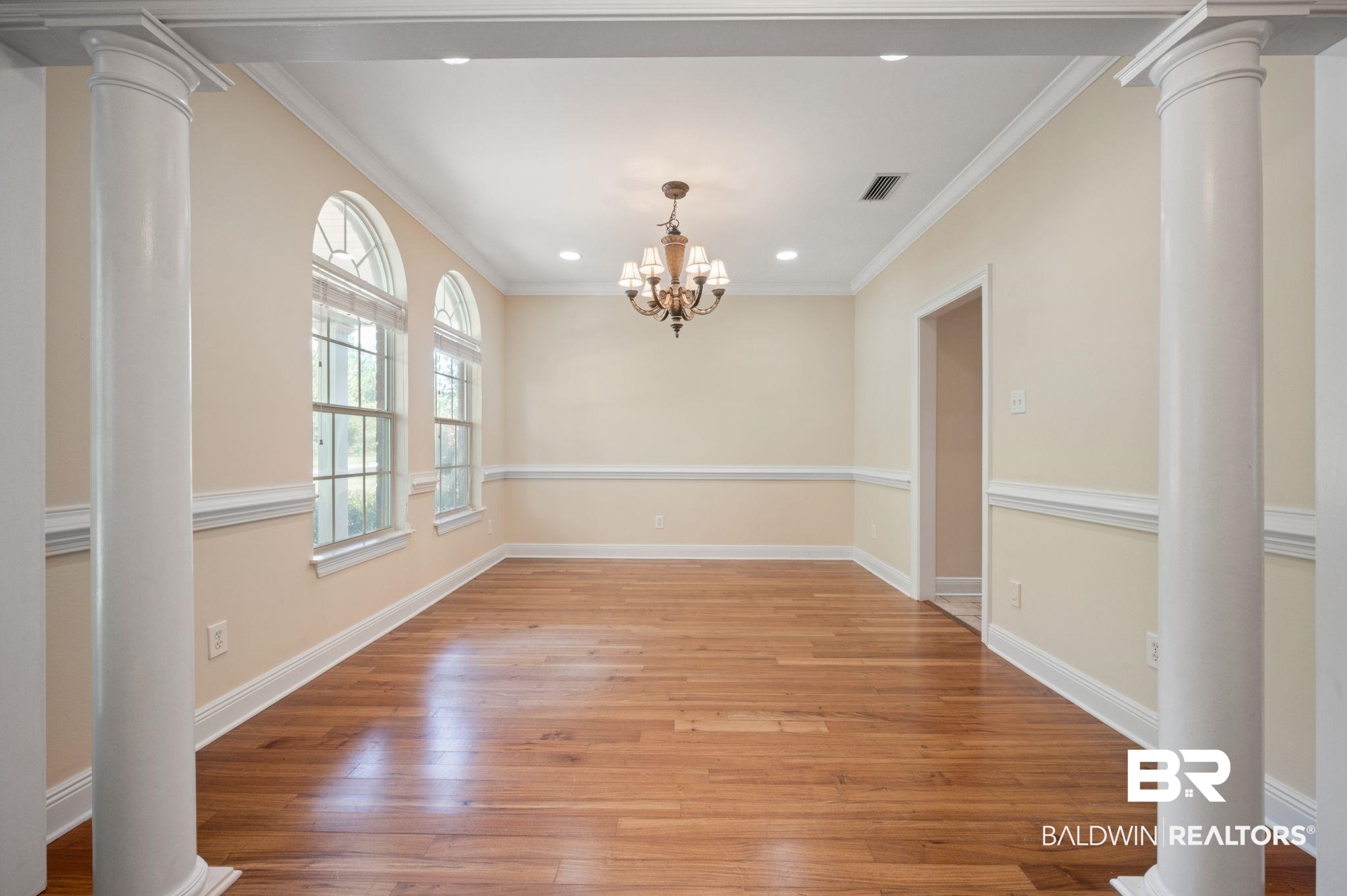 2041 Ridgeline Drive Mobile, AL 36695 - Photo 29 of 43 Unfurnished dining area featuring a notable chandelier, light hardwood / wood-style flooring, decorative columns, and ornamental molding