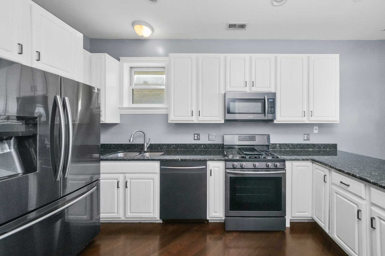 2503 West Harrison Street, Unit 4 Chicago, IL 60612 - Photo 11 of 31 a kitchen with stainless steel appliances granite countertop white cabinets a sink a stove a refrigerator and white cabinets