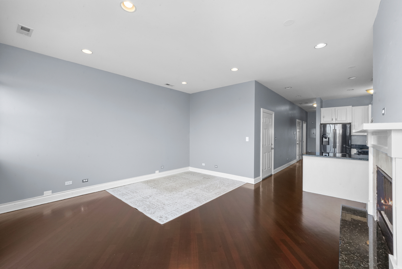2503 West Harrison Street, Unit 4 Chicago, IL 60612 - Photo 8 of 31 an empty room with wooden floor and kitchen view