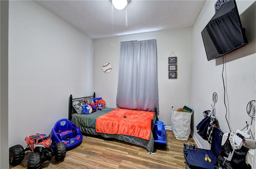 413 Calhoun Avenue Northeast Rome, GA 30161 - Photo 18 of 27 a bedroom with a bed and dresser with wooden floor
