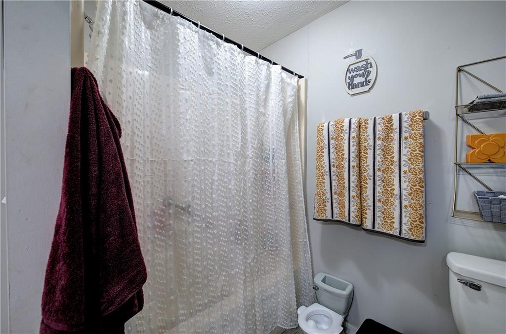 413 Calhoun Avenue Northeast Rome, GA 30161 - Photo 20 of 27 a bathroom with a toilet and a shower curtain
