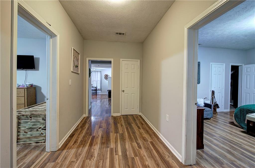 413 Calhoun Avenue Northeast Rome, GA 30161 - Photo 4 of 27 a view of a hallway with wooden floor and a bathroom