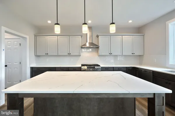 a kitchen with kitchen island a counter top space appliances and cabinets