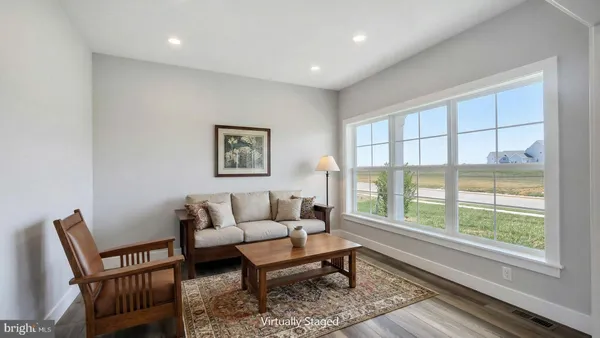a living room with furniture a rug a lamp and a window