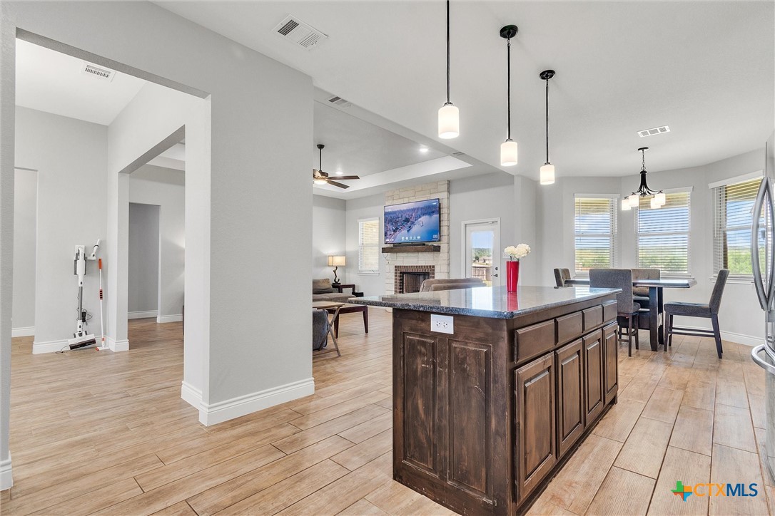 3919 Gracey Lane Kempner, TX 76539 - Photo 20 of 44 a kitchen island with stainless steel appliances kitchen island granite countertop a table chairs sink and wooden floor