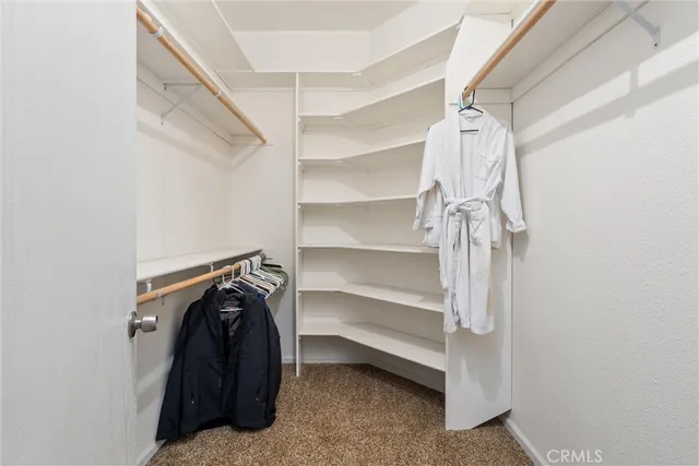 a view of walk in closet with empty racks