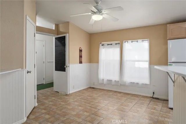 a view of empty room with window and ceiling fan