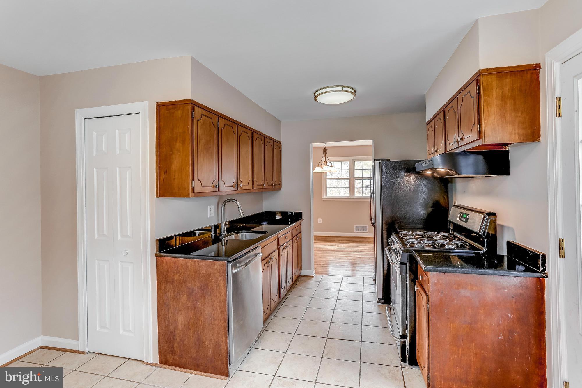 1321 Gresham Road Silver Spring, MD 20904 - Photo 11 of 30 a kitchen with stainless steel appliances granite countertop a stove a sink and a refrigerator