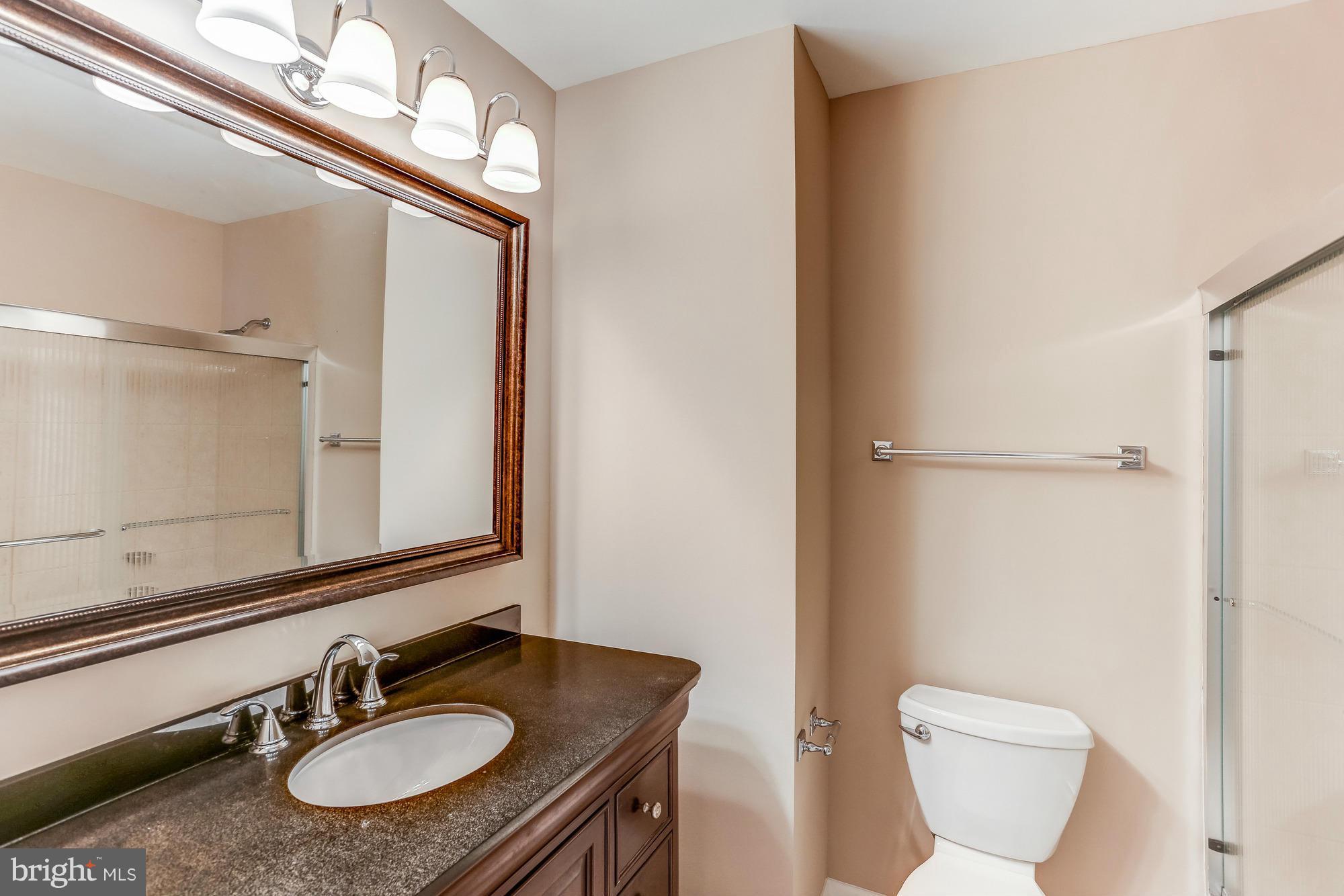 1321 Gresham Road Silver Spring, MD 20904 - Photo 16 of 30 a bathroom with a granite countertop sink toilet and a mirror