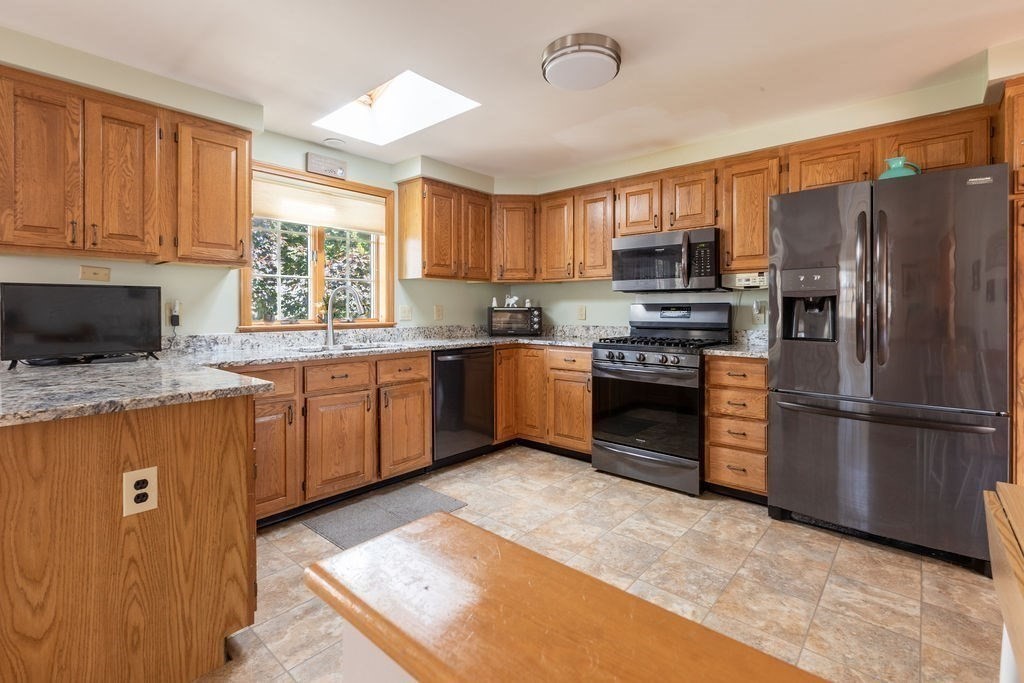 4 Clement Avenue Peabody, MA 01960 - Photo 6 of 25 a kitchen with stainless steel appliances granite countertop a window a sink and a refrigerator