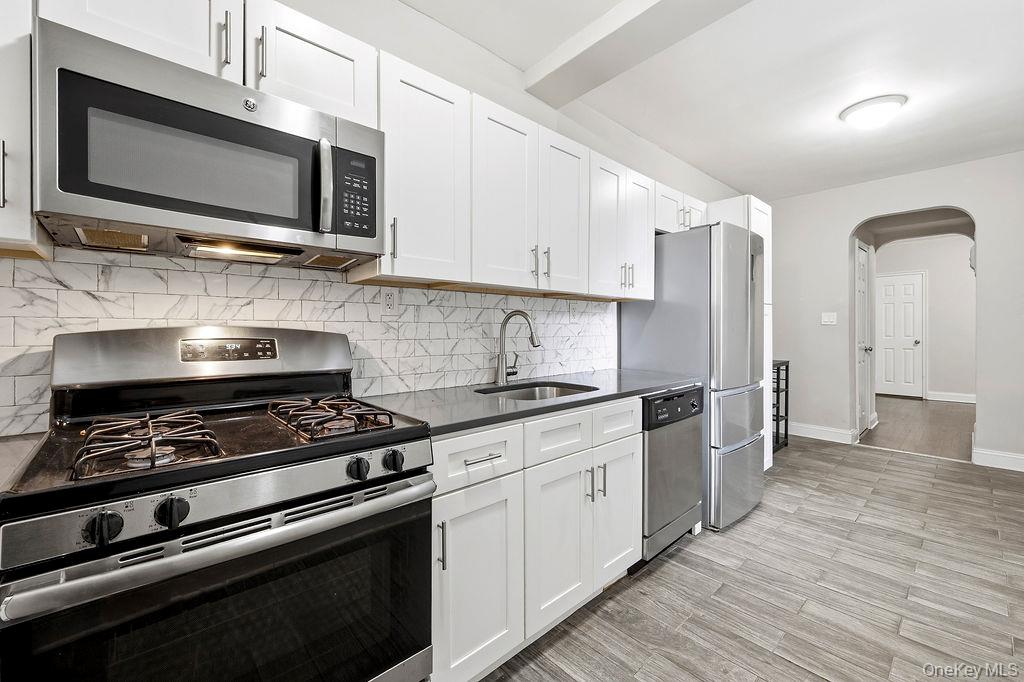 155-01 90th, Unit 3R Queens, NY 11432 - Photo 5 of 16 a kitchen with stainless steel appliances a stove a microwave sink and cabinets