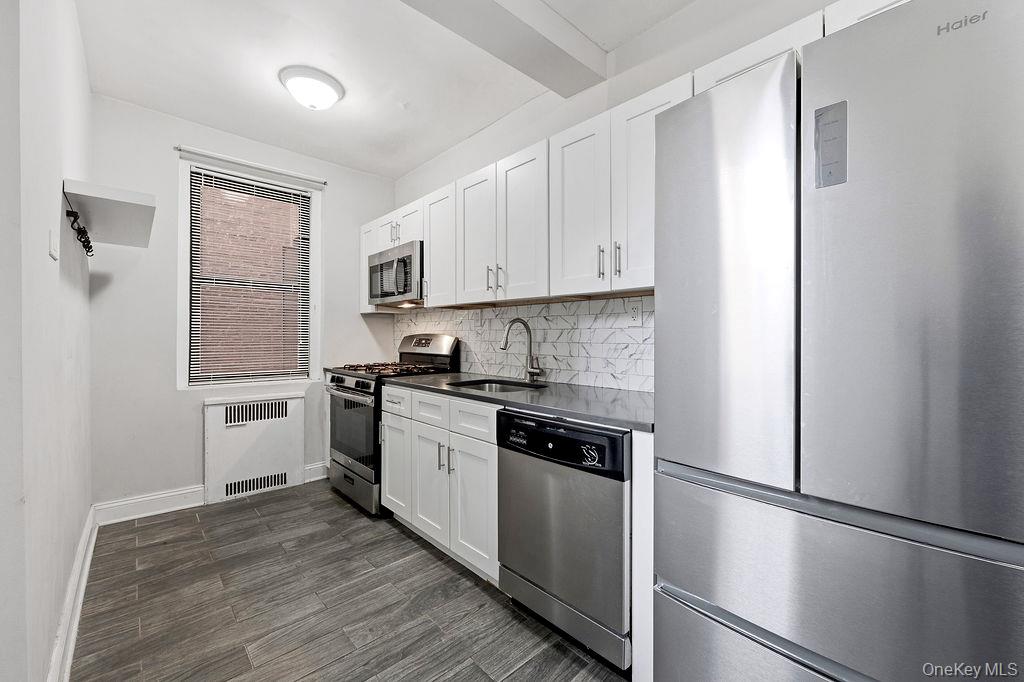 155-01 90th, Unit 3R Queens, NY 11432 - Photo 6 of 16 a kitchen with granite countertop white cabinets and white appliances