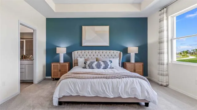 a bedroom with a bed and painting on the wall