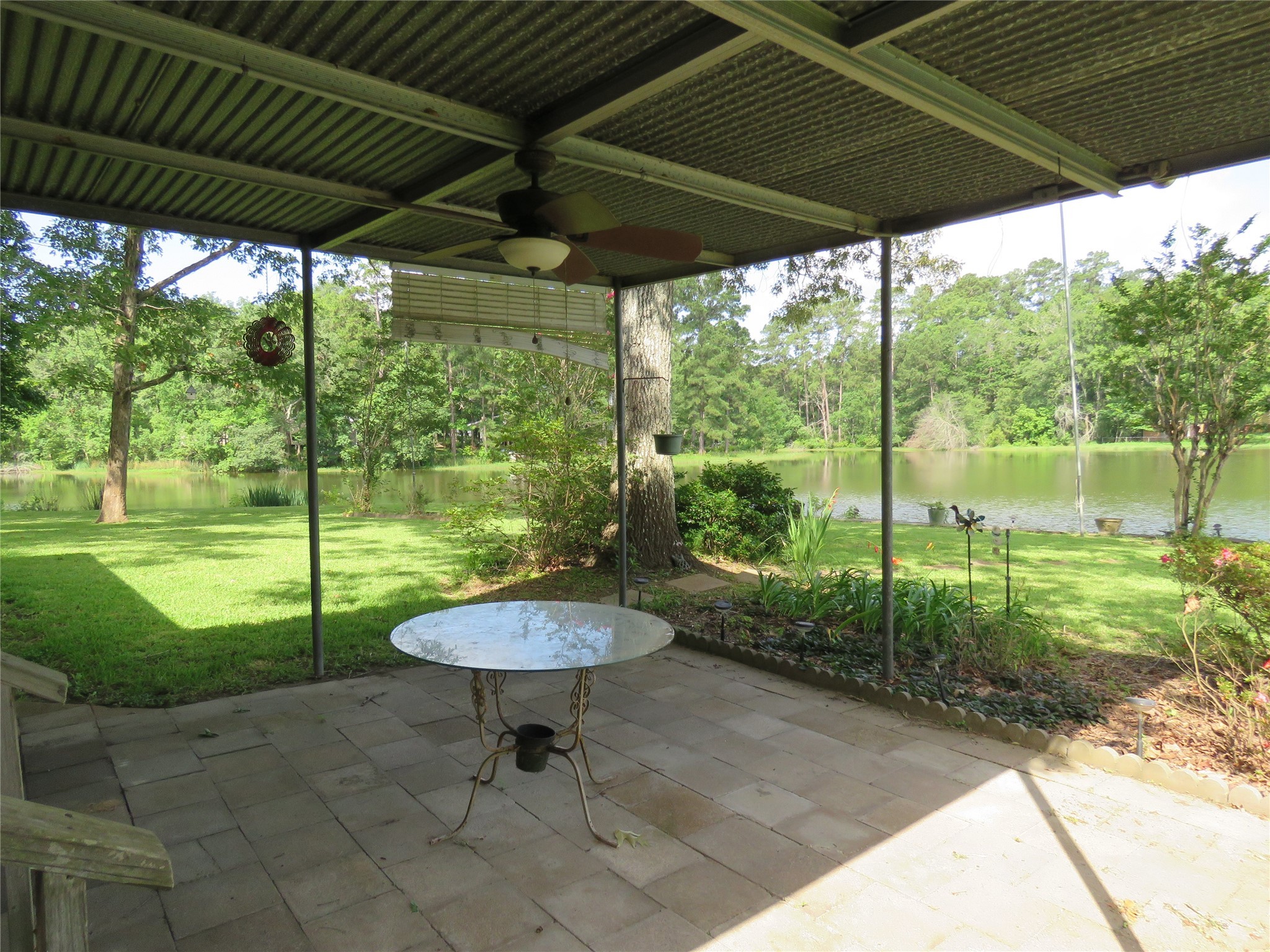 15255 Austin Road Willis, TX 77378 - Photo 7 of 25 a view of a backyard with table and chairs under an umbrella with a small yard