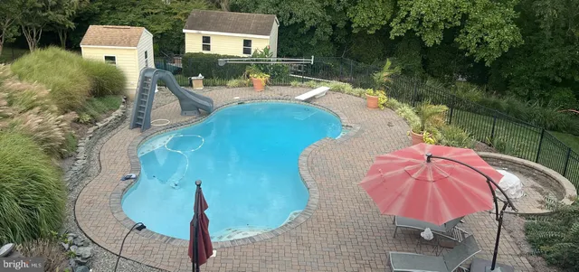 an aerial view of a house with outdoor space and swimming pool