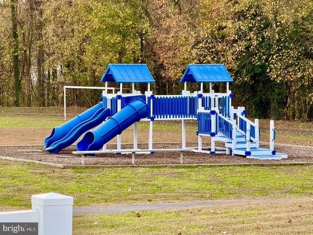 a view of small pool with lawn chairs under an umbrella