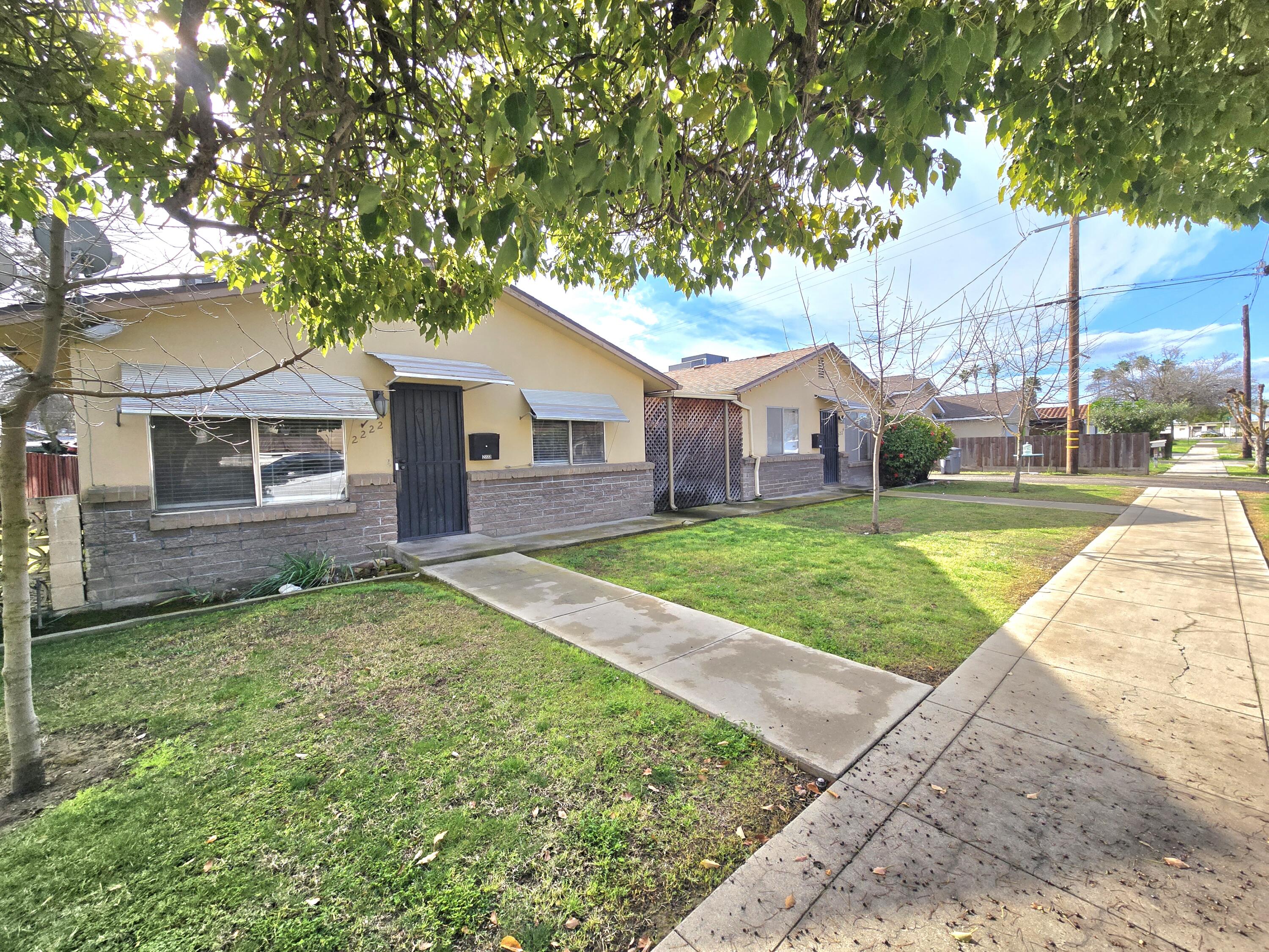 2222-2224 11th Street Reedley, CA 93654 - Photo 1 of 11 a view of a house with a yard and large tree