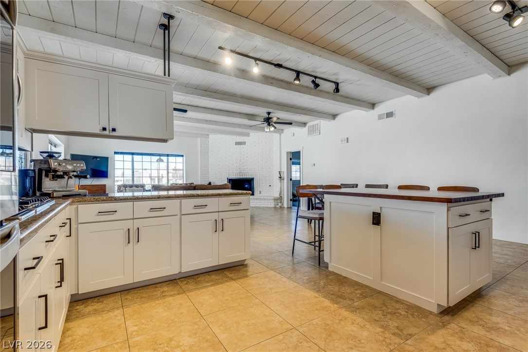 524 Swallow Cove Boulder City, NV 89005 - Photo 16 of 58 A spacious, luminous kitchen with pristine white cabinetry, granite countertops, and exposed beam ceilings.
