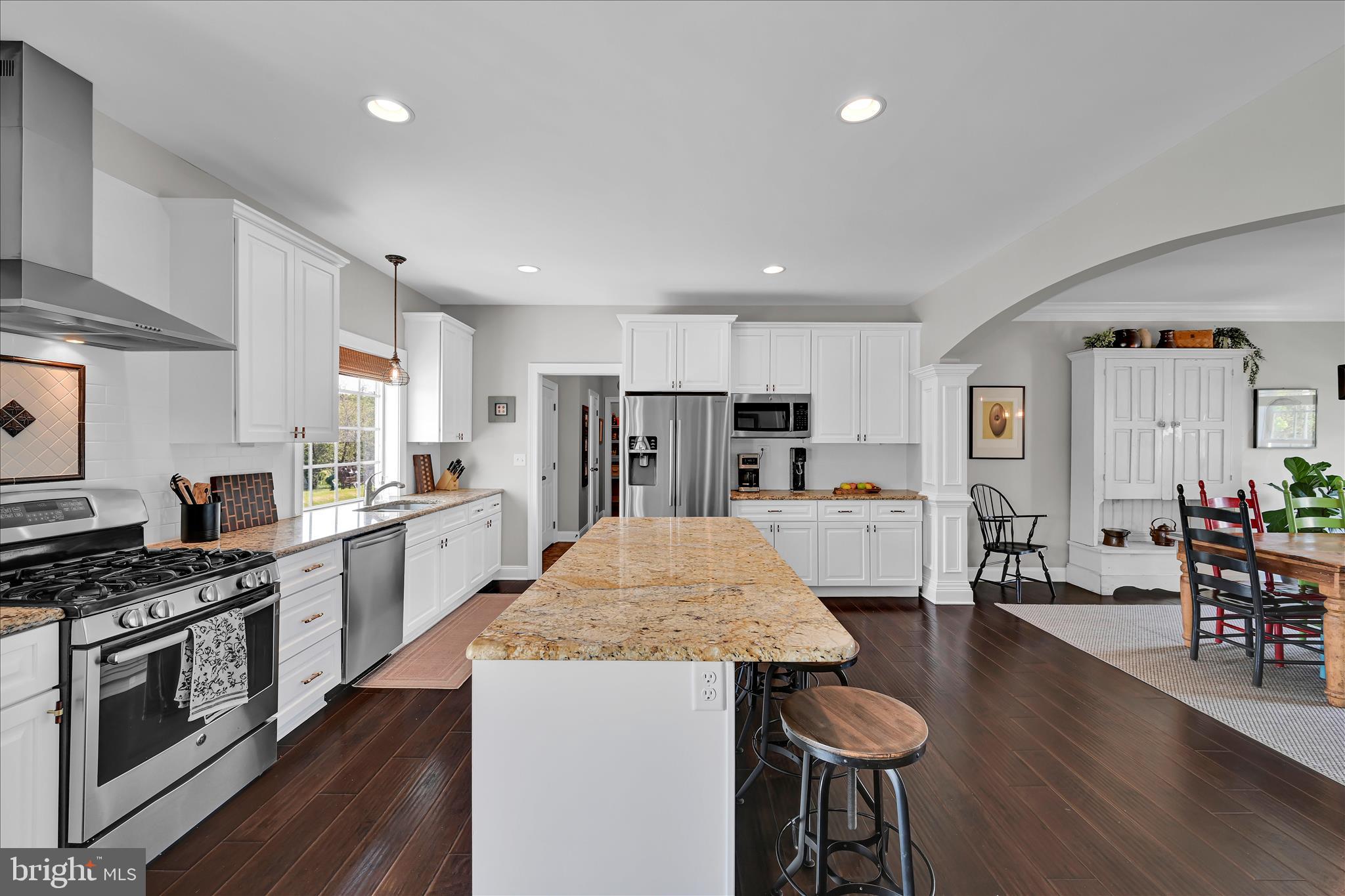678 Integrity Drive Lititz, PA 17543 - Photo 10 of 51 a kitchen with stainless steel appliances kitchen island granite countertop a stove a refrigerator a sink a dining table and chairs with wooden floor