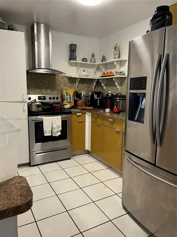 a kitchen with stainless steel appliances granite countertop a stove a refrigerator and a microwave